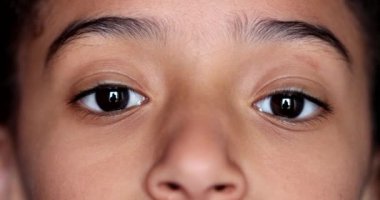 Küçük kız gözleri kameraya yakından bakıyor, makro yakın çekim.