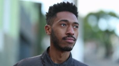 Candid Young African man standing outside observing street
