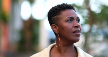 Pensive African woman walking outside. 40s Thoughtful black person thinking