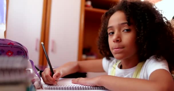 Cute Schoolgirl Smiling Camera While Doing Homework — Stockvideo