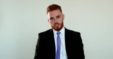 Üzgün adam kameraya tartışıyor. Kızgın iş adamı kameraya konuşuyor, elleriyle işaret ediyor.