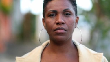 African woman walking towards camera outside. Black lady close-up face portrait