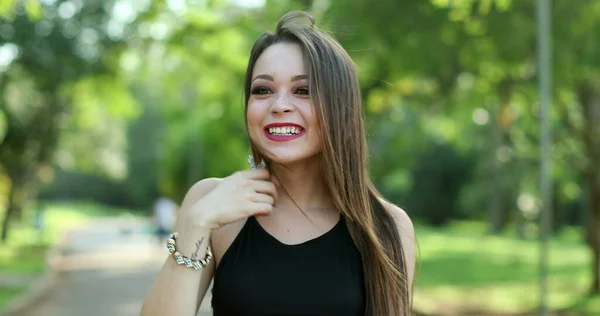Young millennial woman authentic real life laugh and smile in outdoor park. Pretty girl smiling and laughing natural expression
