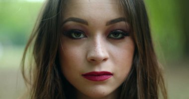 Genç kadın kameraya bakarak gözlerini açıyor. 20 'li yaşlarda oldukça ciddi bir kız.