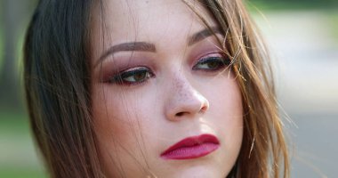 Genç bir kadın, açık havada yakın çekim portresiyle karşı karşıya. 20. yüzyıldaki güzel bir kızın portresi.