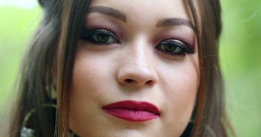 Genç bir kadın kameraya bakarak gözlerini kapatır. Güzel milenyum kızı portresi.