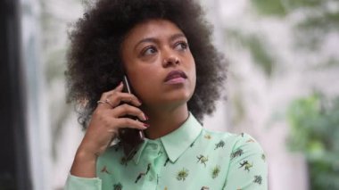 African American young woman making a phone call with cellphone device. A happy black girl putting smartphone on ear