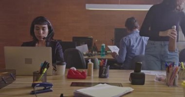 Genç bir erkek çalışanın şirket çağrı merkezindeki kadın meslektaşına doküman vermesi. Başarılı ekip bilgisayarların önünde iletişim kuruyor. Gece takım çalışması fazla mesai