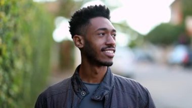 Smart black man walking outdoors in sidewalk