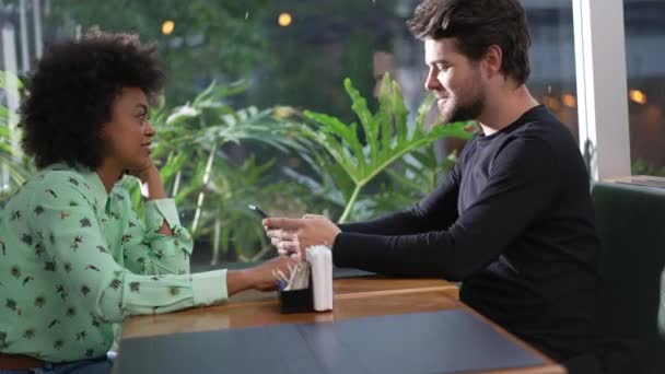 Jeune Couple Diversifié Assis Table Café Homme Regardant Appareil Smartphone — Video