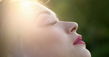 Cazibeli Gil 'in gözleri dışarıda, güneş ışığının parıltısında meditasyon yaparken kapalı.