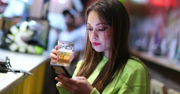 Chica Bonita Cándida Bar Beber Cerveza Comprobar Teléfono Inteligente — Foto de Stock