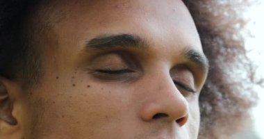 Young african man closing eyes in contemplation and meditation, opening eyes, feeling confident