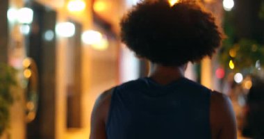 African man walking outside in night during drizzle