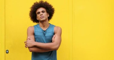 Upset angry african american black man crossing arms looking to camera with yellow background