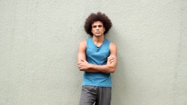 Young black man leaning on wall