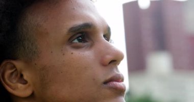 Handsome young black african man taking a deep breath, meditating and smiling