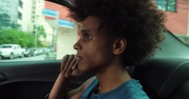Young contemplative african man in backseat of a car thinking and daydreaming