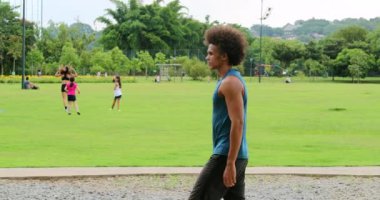 Handsome african man walking at park outside