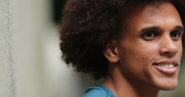 Happy young mixed race man smiling looking up at sky feeling faith and hope