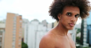 Young handsome african american man posing to camera with stoic expression