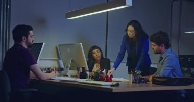 Toplantıda kadın yönetici lider takım. İş kadını, çalışanların önünde başarıya giden yolda gruba rehberlik eder. Personel gece geç saatlere kadar iş yerindeki planlama stratejisinde çalışıyor.