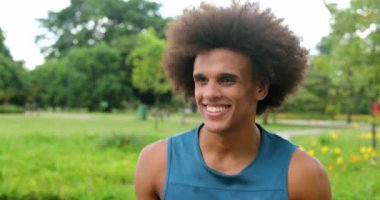African young black man walking at park smiling feeling happy