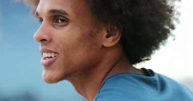Handsome young mixed race black african man smiling and feeling happy