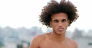 Mixed race handsome young man looking to camera with serious stoic expression