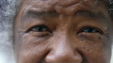 Üst düzey bir Afrikalı kadın makro yakın çekim yüzü ve gözleri kameraya bakıyor.