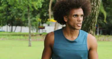 Mixed race man walking forward towards camera portrait serious at park