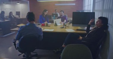 Geceleri ofis içi işyerinde çalışan insanlar. Ortak çalışma alanındaki yoğun çalışanların iç mekanları. Şirket işadamları ve iş kadınları masalarında oturuyor ve iş yerinde yürüyorlar. Ofis hayatı fazla mesai