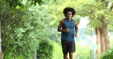 Young handsome african man running at park