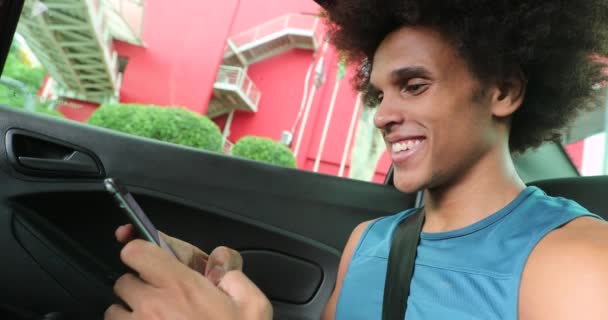 Young Black Male Backseat Car Smiling Looking Smartphone Screen — ストック動画