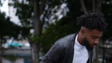 Caddede yürüyen düşünceli bir adam Brezilyalı bir adam öne yürüyor.