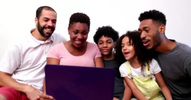 African family talking with relatives on webcam laptop at home couch