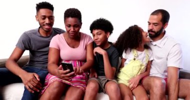 Casual interracial happy family sitting at home couch
