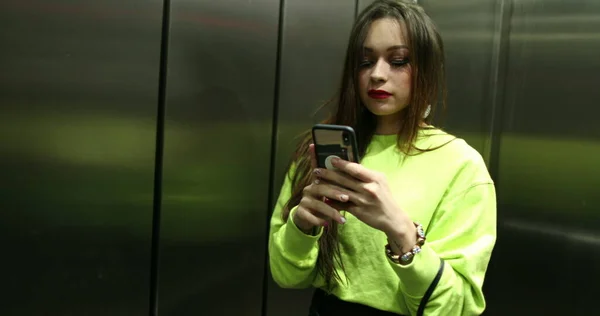 여자가 엘리베이터 앞에서 자신의 사진을 — 스톡 사진