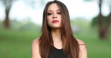 Kendine güveni tam genç bir kadının portresi kameraya bakıyor.