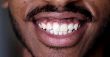 Dudakları makro yakın plan, siyah Afrikalı adam gülümsüyor.