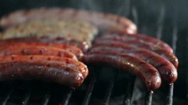 Frying sausages on grill. Grilling many hot dogs at BBQ