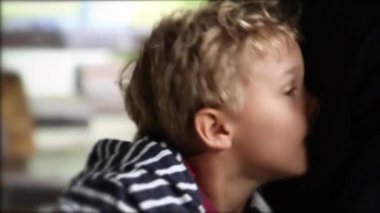 Cute child hiding from camera, kid hides from viewer using parent arm. Toddler peeking out