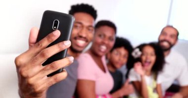 Mutlu siyah aile akıllı telefonuyla selfie çekiyor.