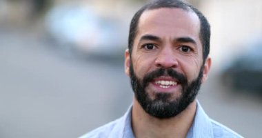 40 'larda gülümseyen İspanyol bir adam. Sıradan biri kameraya bakıyor.