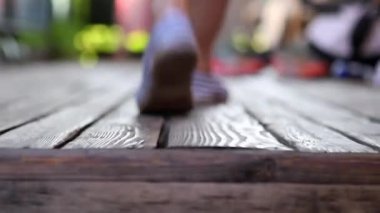 People arriving home, close-up hardwood wooden balcony floor legs and feet arrive