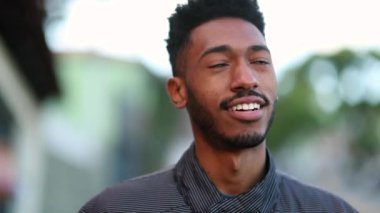 Happy young black man walking outside. Mixed race African guy portrait close-up face