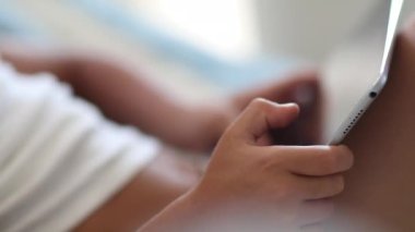 Child hands close-up using tablet, Closeup kid hand holding tablet