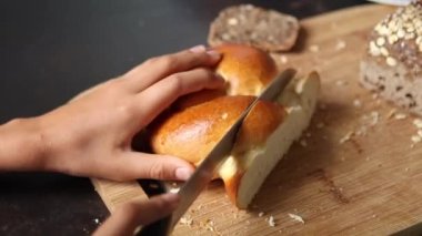 Hands cutting slice of bread brioche close-up