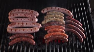 Frying sausages on grill. Grilling many hot dogs at BBQ
