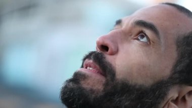 Hopeful middle aged man opening eyes to sky with FAITH and BELIEF
